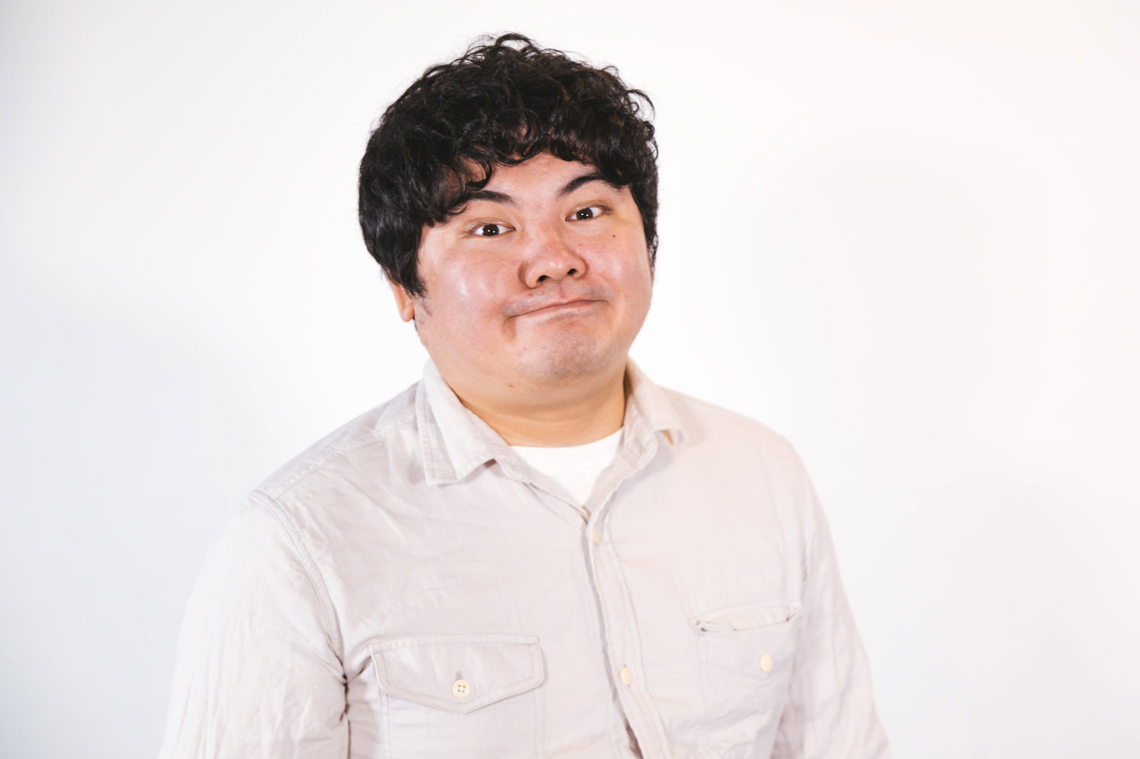 白いシャツを着た男性がドヤ顔で上を見上げている様子［モデル：段田隼人］