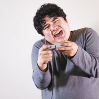 レースゲームをプレイしていると体を傾けちゃう系男性ゲーマーの写真