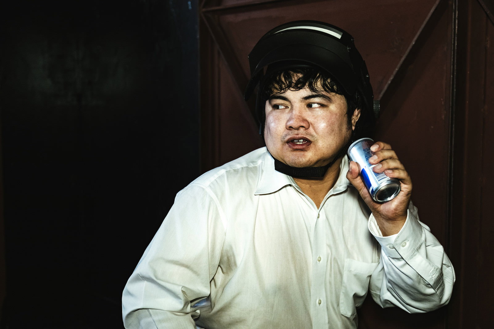 エナジードリンクを飲みながら緊張した表情を見せる男性［モデル：段田隼人］