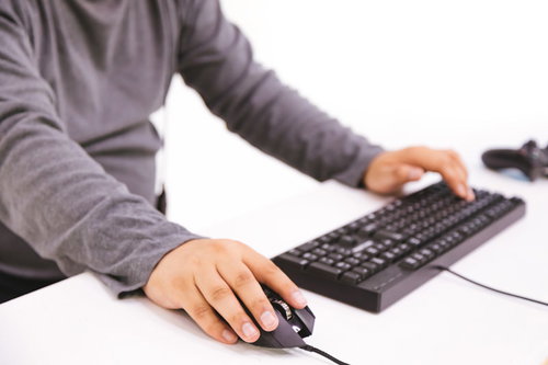 ゲーミングマウスを握ってFPSをプレイするゲーマー