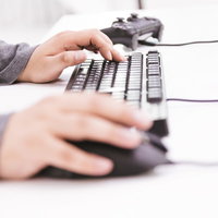 Wキーに中指を置いてFPSをする男性ゲーマーの手元の写真