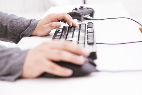 Wキーに中指を置いてFPSをする男性ゲーマーの手元