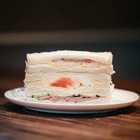 白いお皿に盛り付けたハムたまごきゅうりのサンドイッチの写真