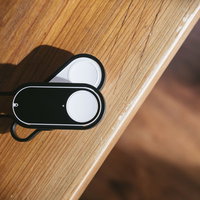 木製テーブルに置かれた白と黒のダッシュボタンの写真