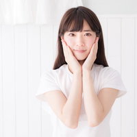 スキンケア後に両手を頬の横で合わせる女性の写真