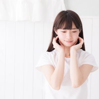 透明感ある細身の女性が頬杖をつくポーズの写真