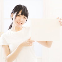 脱毛してこういう風になりたいと言ってくる人、白いパネルを持って笑顔でポーズの写真