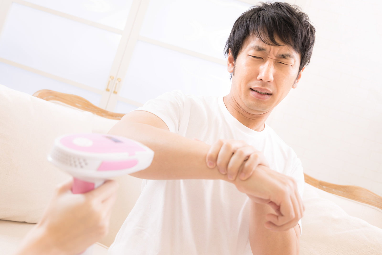 脱毛を怖がって痛がる表情を見せる男性［モデル：大川竜弥］