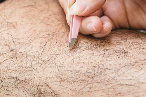 毛抜きですね毛を処理する男性の手のセルフケア