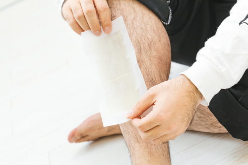 すね毛に脱毛シートを貼り付ける様子