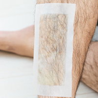 表面からも確認できる脱毛シートの粘着面と男性のすね毛の写真