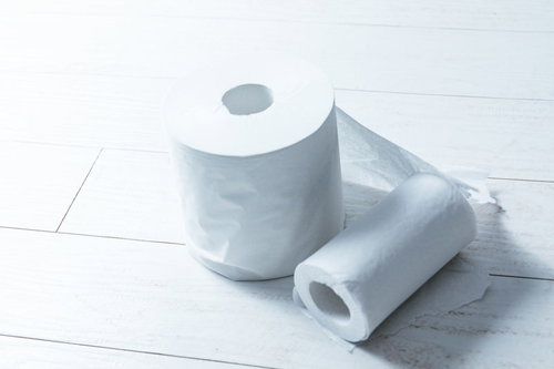 白い床に転がるトイレットペーパーの複数ロール