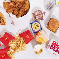 ピザやフライドポテト、ハンバーガーなどのファーストフード詰め合わせの写真