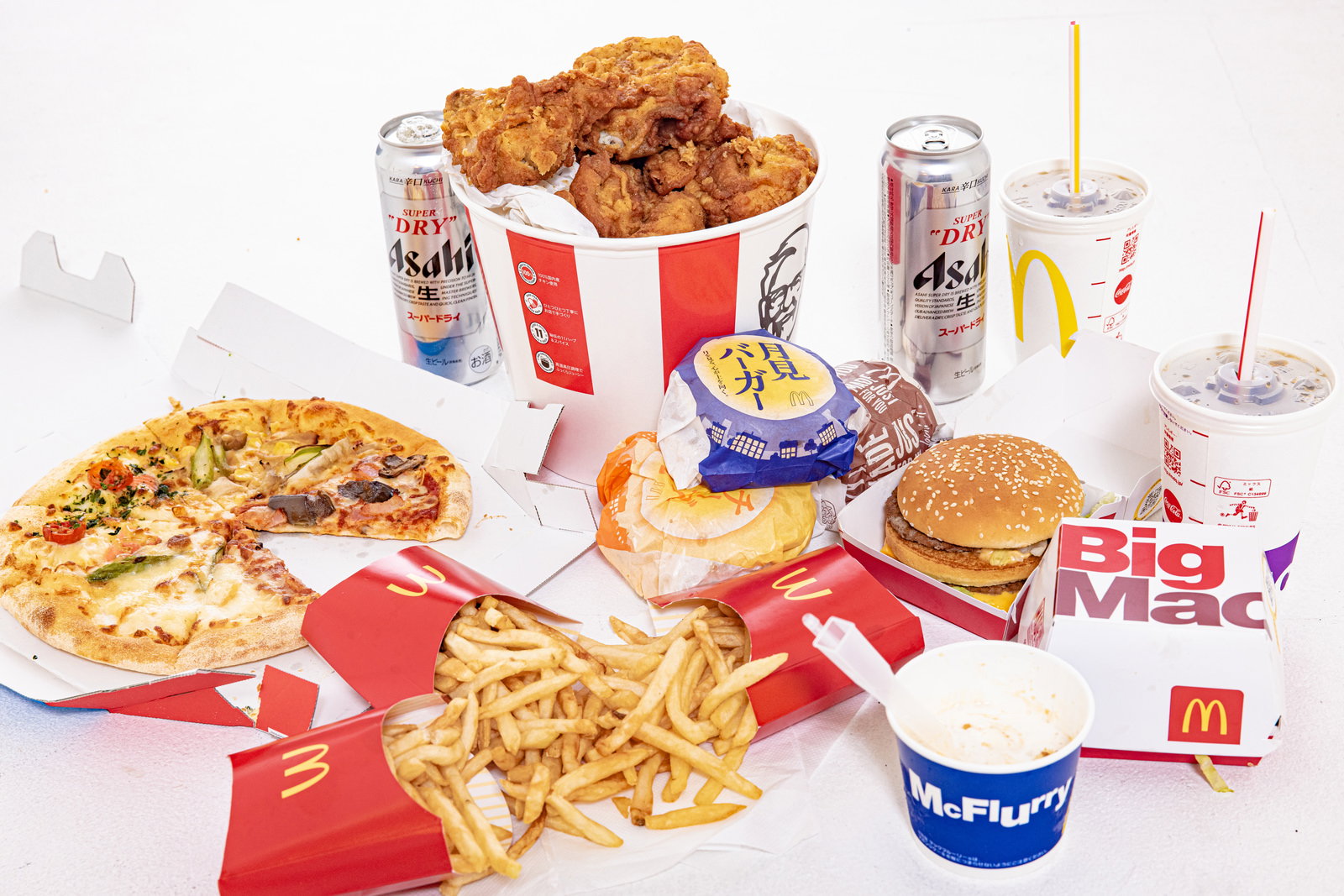 ピザ、ハンバーガー、フライドチキンなど高カロリー食品とドリンクが並んだセット