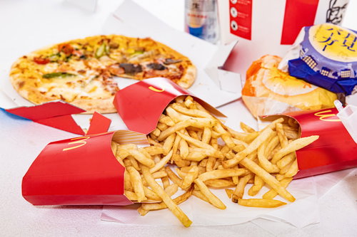 赤いケースから溢れるフライドポテトとピザ