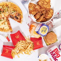高カロリーの食べ物勢ぞろい、ピザとフライドチキンの写真