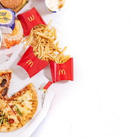 フライドチキンやピザ、フライドポテトなどのジャンクフードの写真