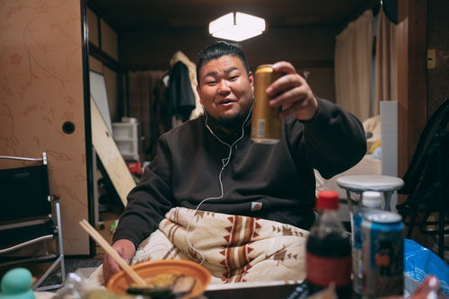 リモート飲みでビールとラーメンで乾杯する男性