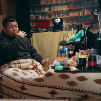 手についた食べ残しを舐める男性の不潔な食生活習慣の写真