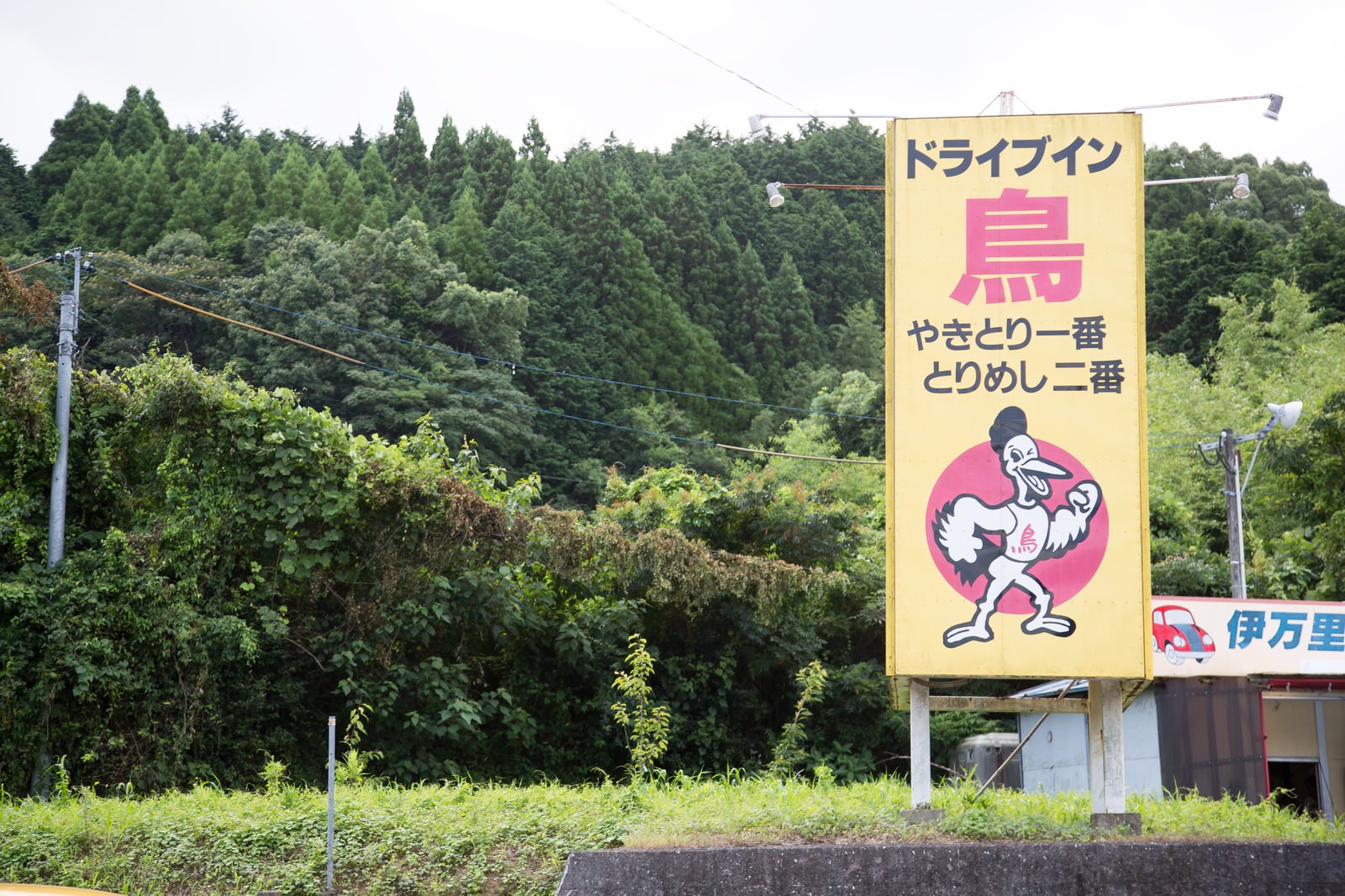 黄色い看板に焼き鳥のキャラクターが描かれたドライブイン鳥の看板