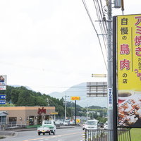 伊万里市のアミ焼き専門店の看板と国道沿いの風景の写真