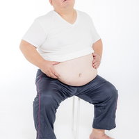 お腹の肉がものすごい男性のメタボ体型と健康診断の写真