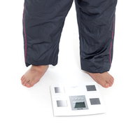 体重計に乗る裸足の男性 - 健康管理と運動不足改善の写真