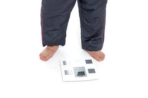 体重計に乗る裸足の男性 - 健康管理と運動不足改善