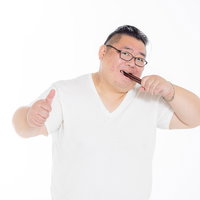 ポッキーをまとめて貪り食う膨よかな男性の暴食シーンの写真