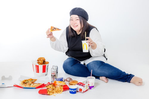 ジャンクフードに囲まれて暴飲暴食に目覚める女性