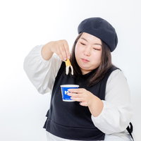 アイスにポテトをつけて食べるうまい女性のジャンクフードの写真