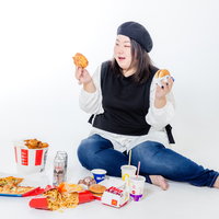 ファーストフードに囲まれて微笑む女性の写真