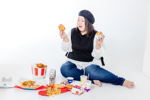 ファーストフードに囲まれて微笑む女性