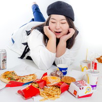 ファストフード商品を前に顎のせポーズする女性の写真