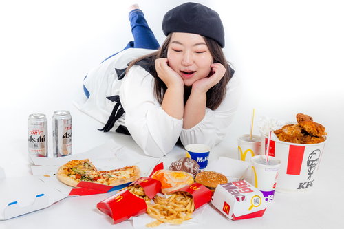 ファストフード商品を前に顎のせポーズする女性