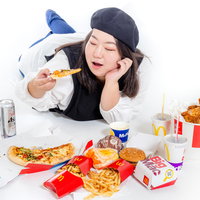 休日にジャンクフードを食べる女性の写真