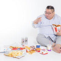 ジャンクフードを物色するダラダラと食べ過ぎる暴食中の男性の写真