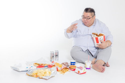 ジャンクフードを物色するダラダラと食べ過ぎる暴食中の男性