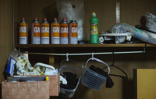 カセットガスとサンポールが雑然と置かれた汚い棚