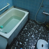 タイル貼りの昭和懐かしいお風呂場。白と黒のモザイク床の写真
