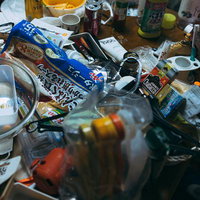 薄暗い食器棚に赤いケースが見える木製のキッチン収納の写真