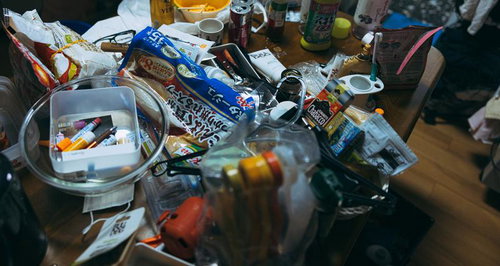 薄暗い食器棚に赤いケースが見える木製のキッチン収納