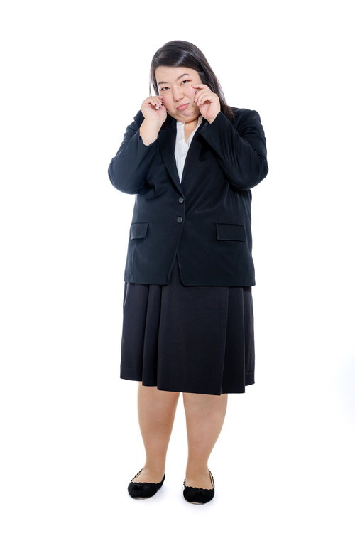 頬に手を当てて泣きまねする困った表情の女性会社員