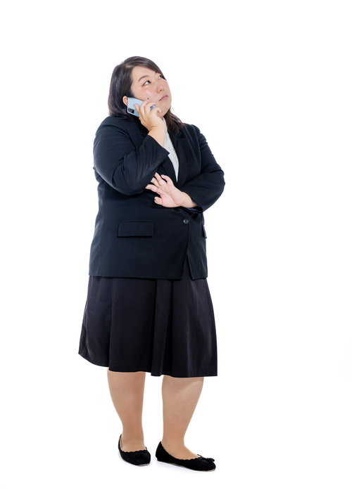 黒いスーツでスマートフォン通話中の女性会社員