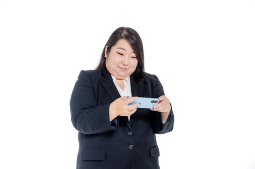 スマホで動画を見ているOLの二重あご、ぽっちゃり体型