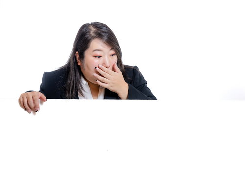 下の広告を見て驚く太った女性のビジネスウェア姿