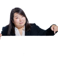 下を指差してポイントを示す女性会社員のジェスチャーの写真