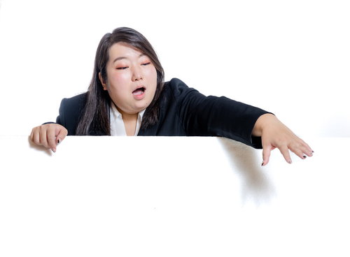 塀越しに手を伸ばして掴む女性会社員、目標達成への挑戦