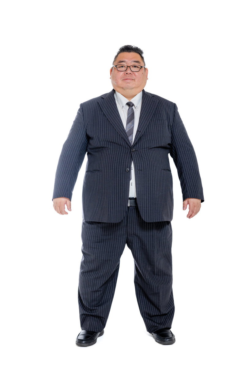 紺色のストライプスーツを着た中年男性の正面姿［モデル：ダルマ親方］