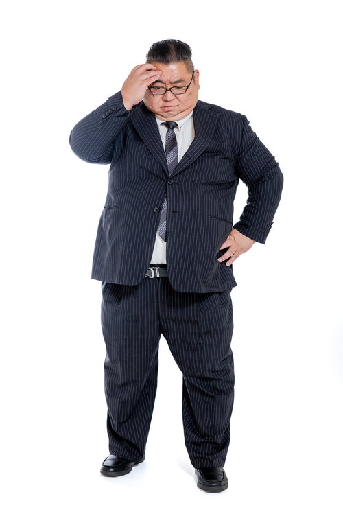 はち切れそうなスーツ姿で頭を掻く困惑する会社員の男性